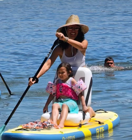 woman paddling her child on an inflatable paddle board