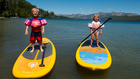 two kids on paddle boards