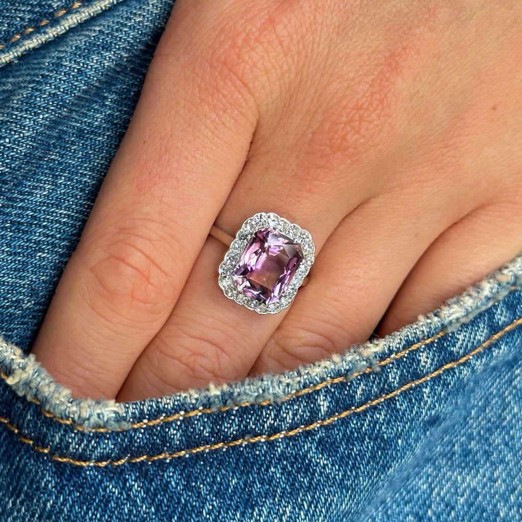 antique belle epoque amethyst and diamond cluster ring worn on hand in pocket of jeans.