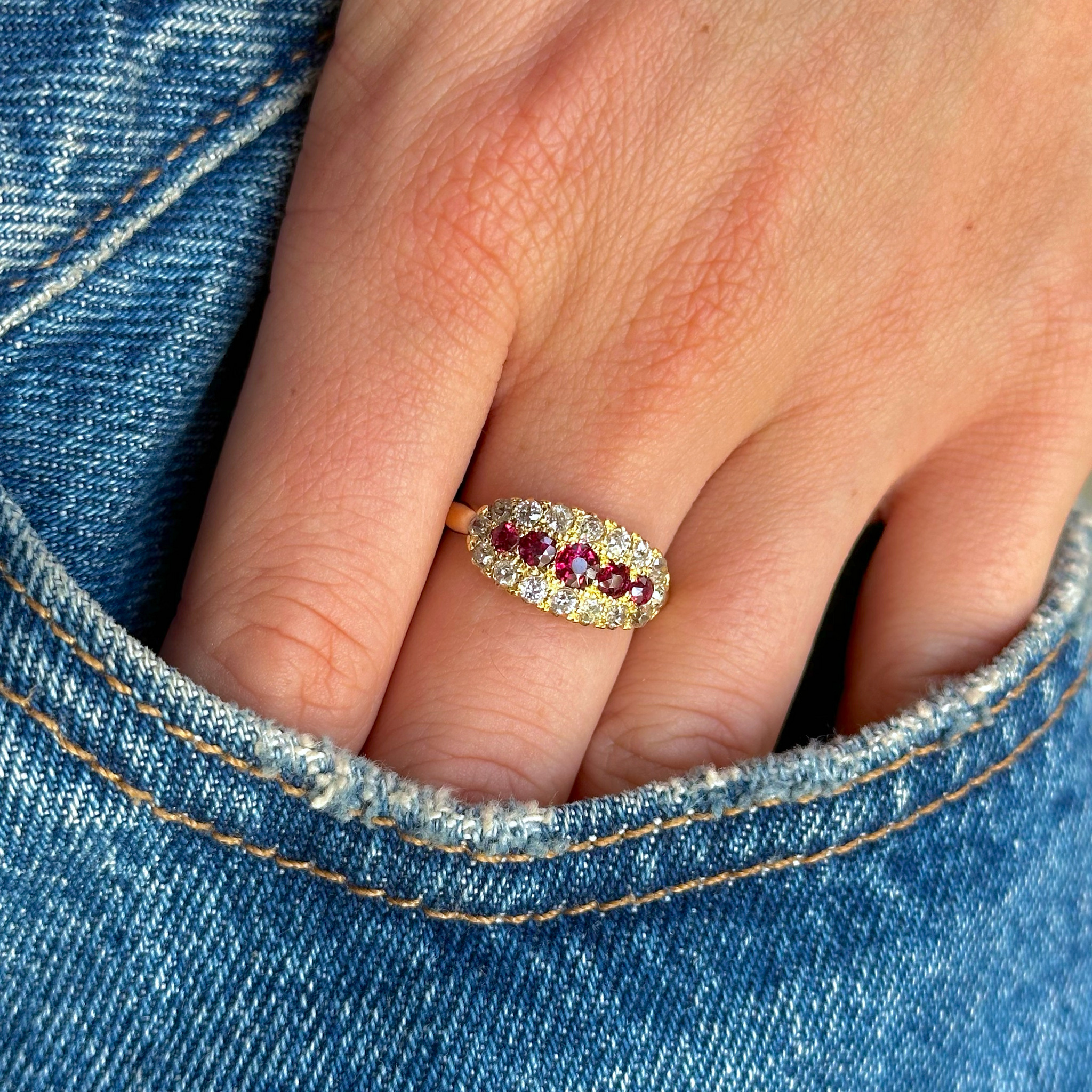 ruby and diamond five stone ring worn on hand in pocket of jeans