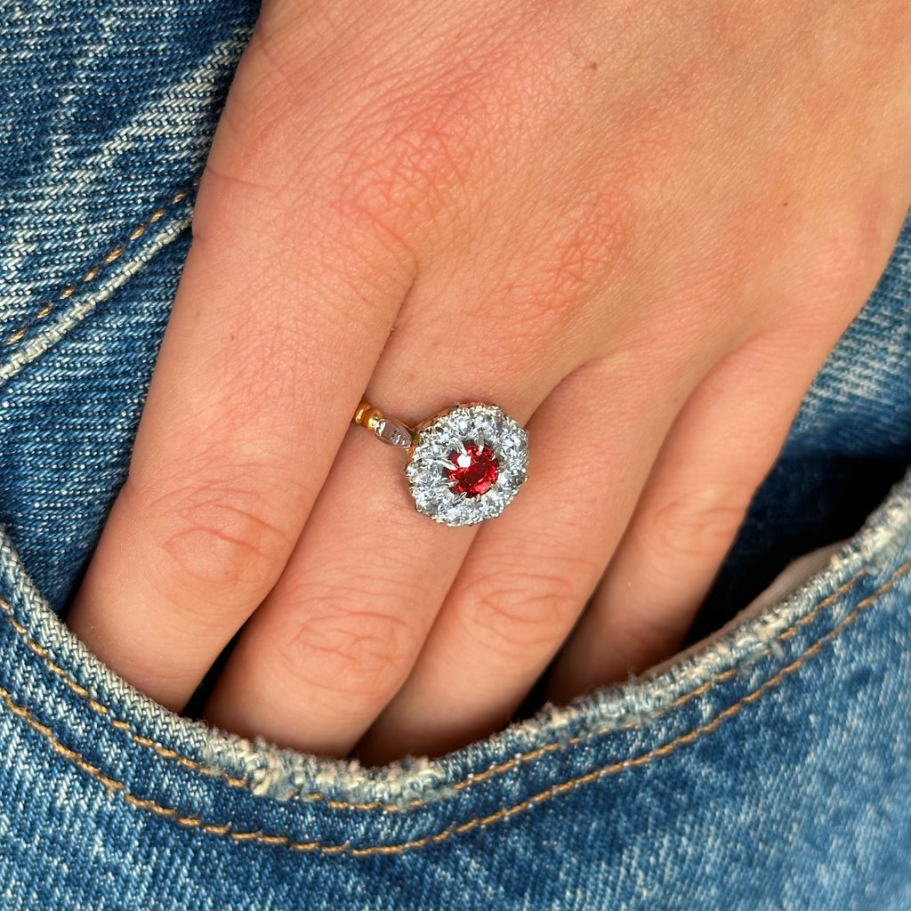 Antique ruby and diamond cluster engagement ring worn on hand in pocket of jeans.