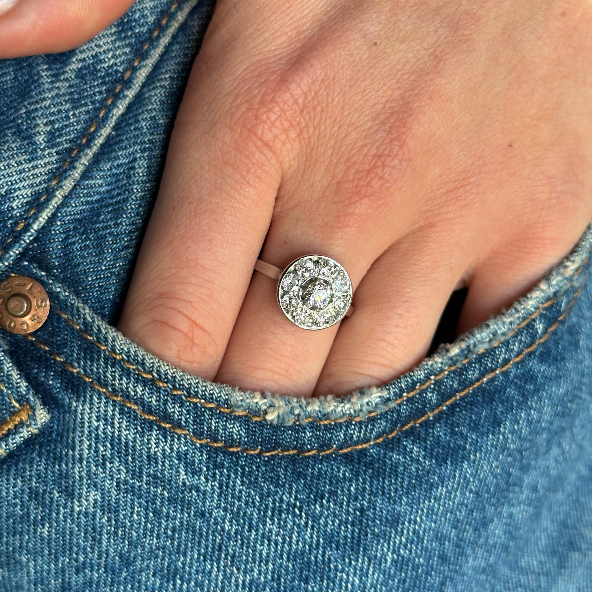 Art deco diamond cluster ring worn on hand in pocket of jeans