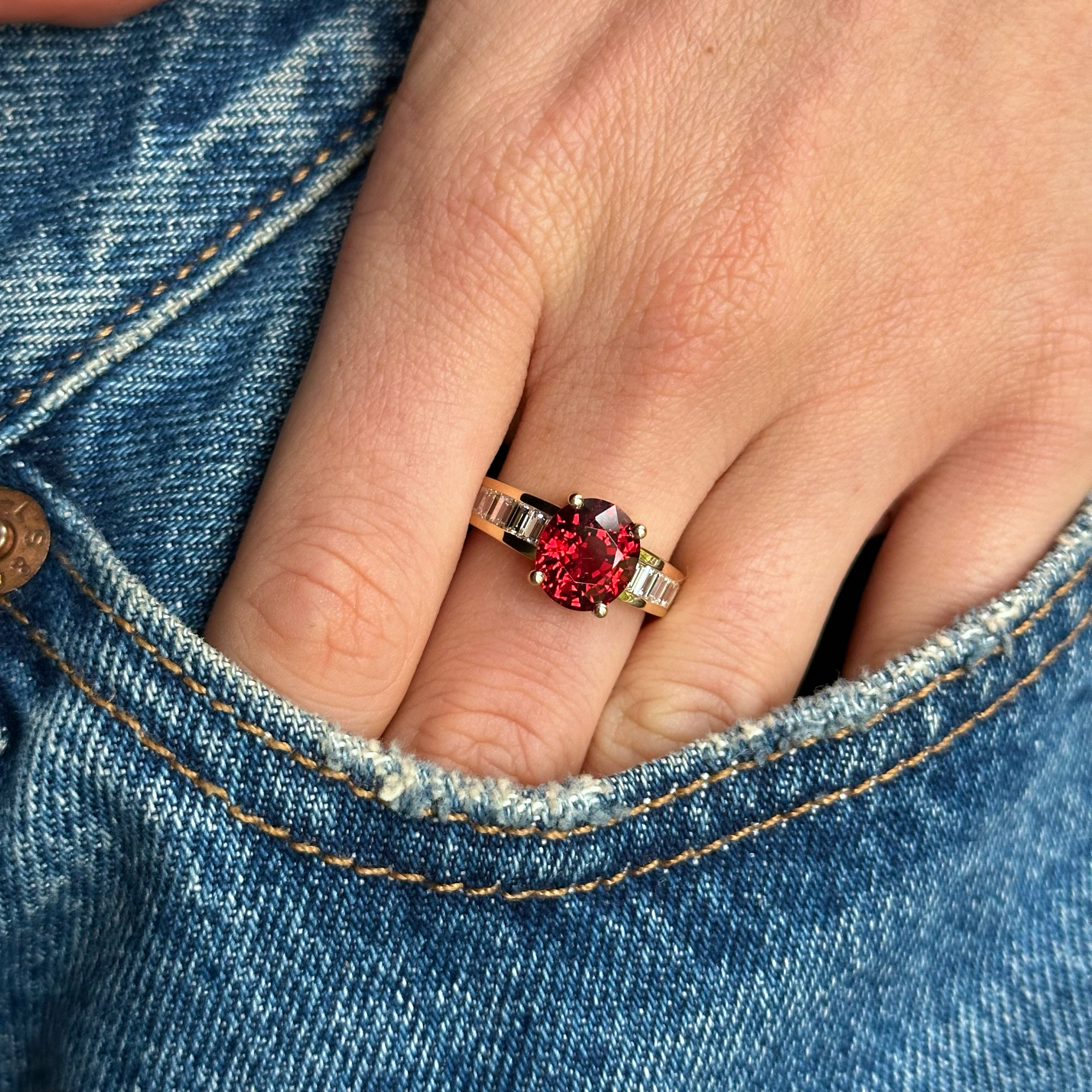 spinel and diamond ring worn on hand in pocket of jeans.