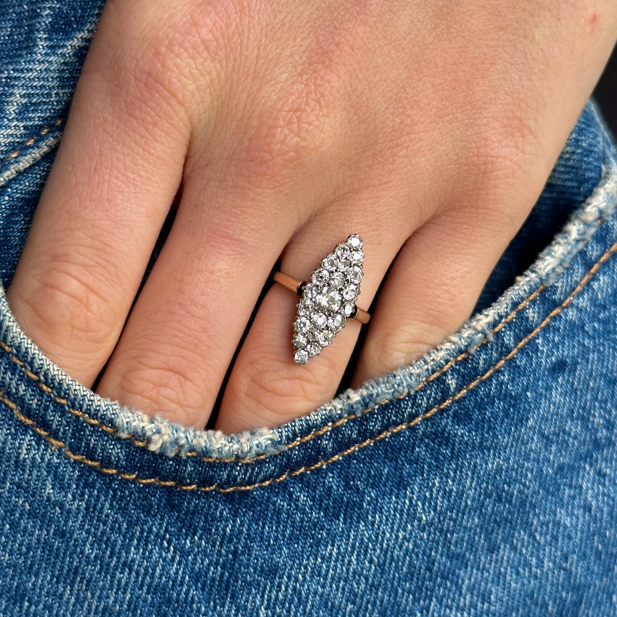 Diamond navette ring worn on hand in pocket of denim jeans