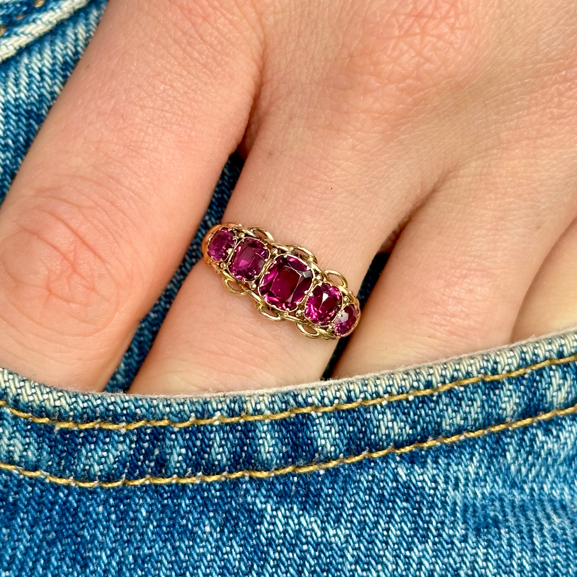 Victorian five stone garnet ring worn on hand in pocket of jeans