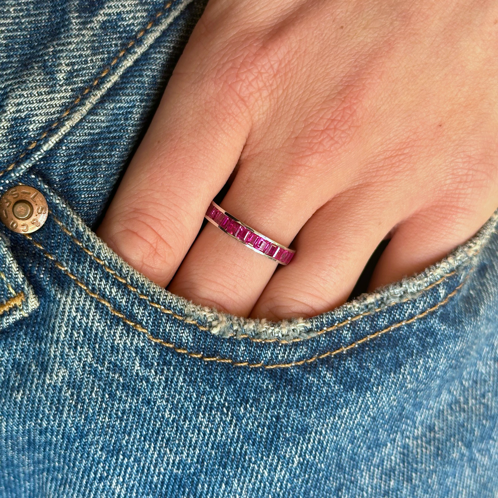 Ruby eternity ring worn on hand in pocket of jeans