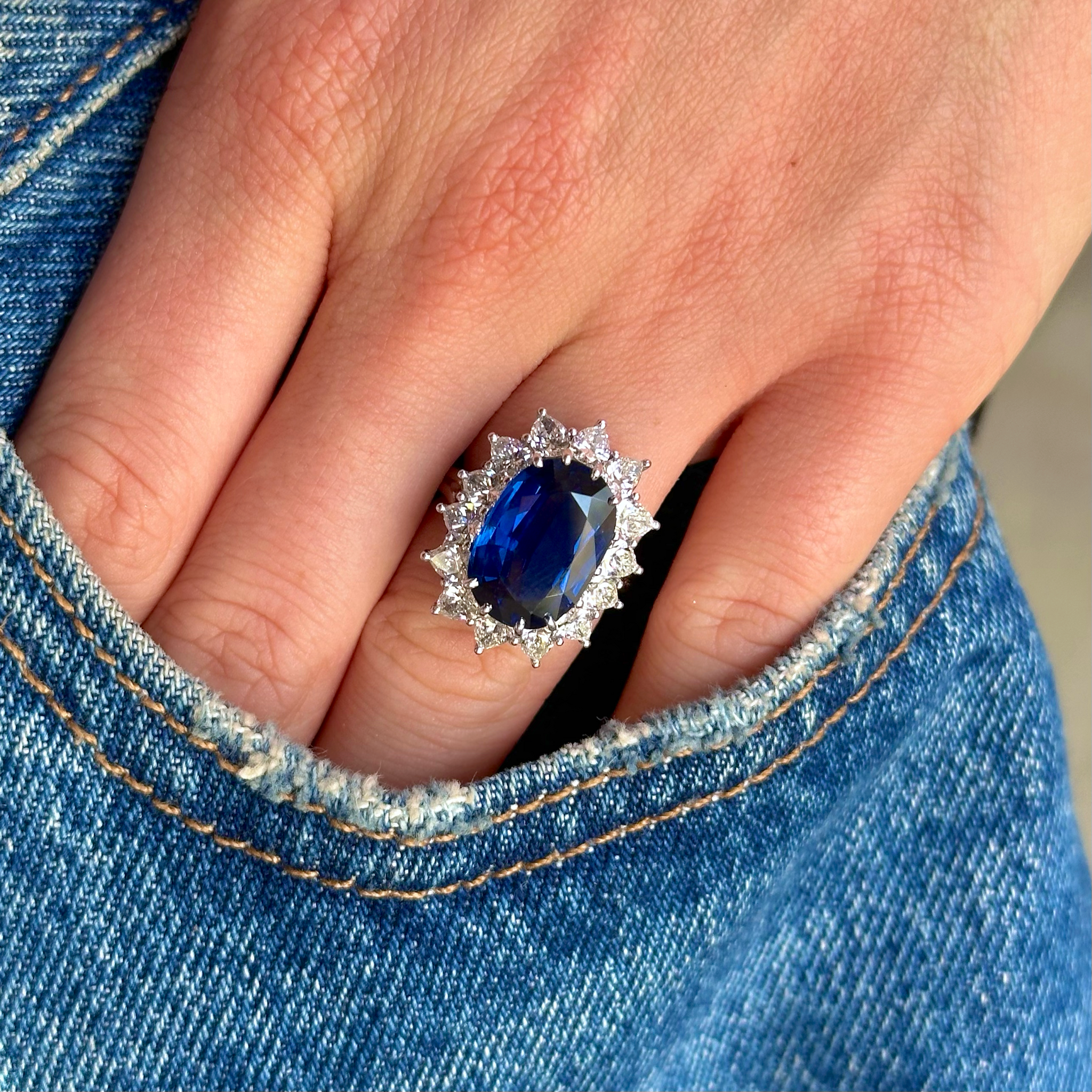 vintage sapphire and diamond cocktail cluster ring worn on hand in pocket of jeans.