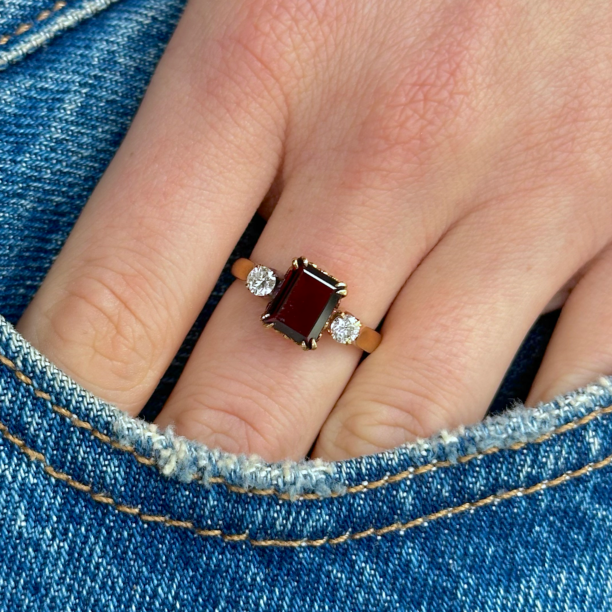 Antique, three-stone garnet and diamond ring, worn on hand.