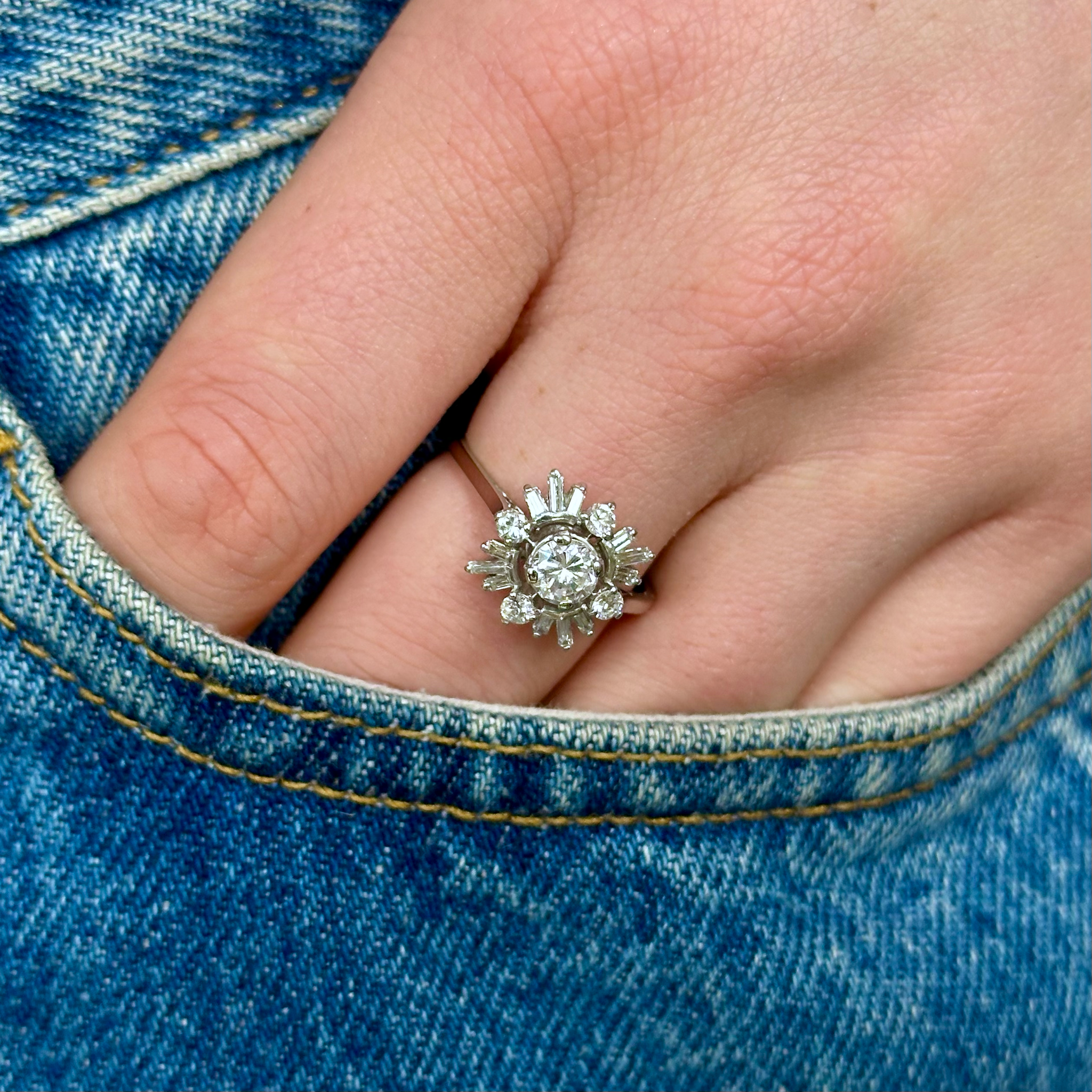 Vintage diamond cluster ring worn on hand.