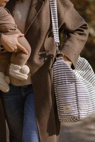 A mom carries the Stripes Away Diaper Bag