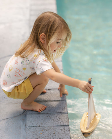Toddler girl in Pehr outfit playing by pool