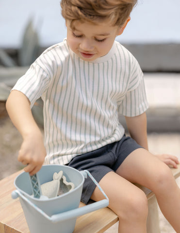 Toddler boy playing with sand pail