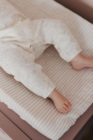 baby's legs and feet wearing pajamas on changing table 