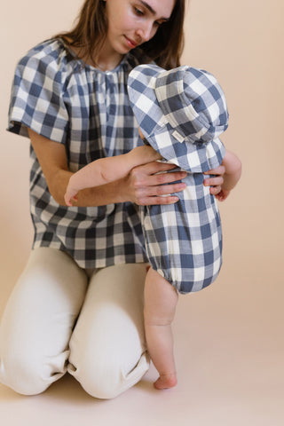 A mom holding her baby in Checkmate clothing