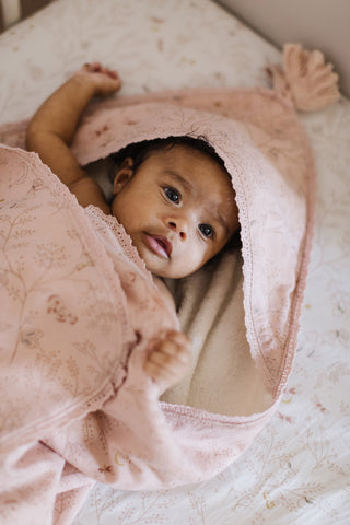 Image of an infant wrapped in Pehr's Secret Garden Hooded Towel.