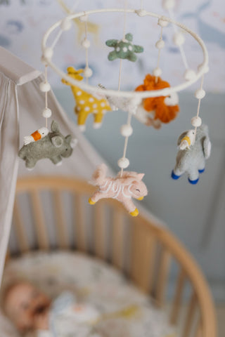 Baby in crib with handmade mobile