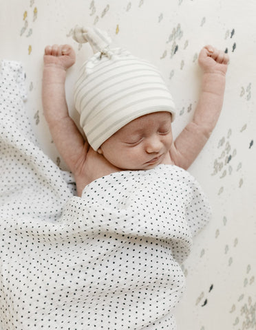 baby in hat and swaddle