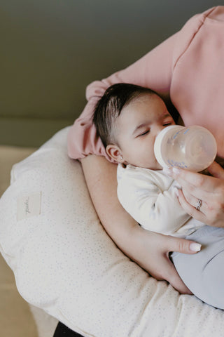 mother feeding baby with bottle