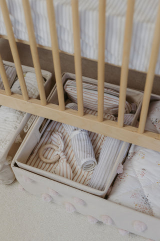 An image with Pehr’s canvas hideaway storage under a crib.