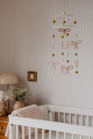 pink bow mobile hanging above crib