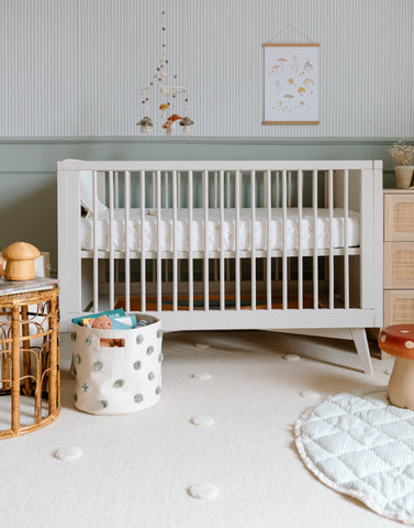 crib with pom pom storage and playmat