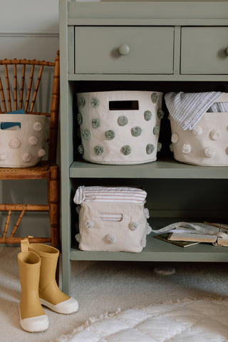 An image of Pom Pom Bins on a shelf in a nursery.