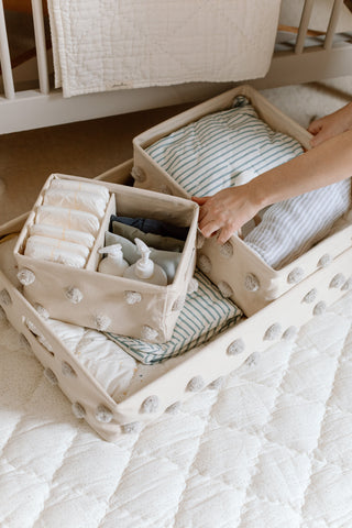 An image of Pom Pom Hideaway storage being filled with nursery items.