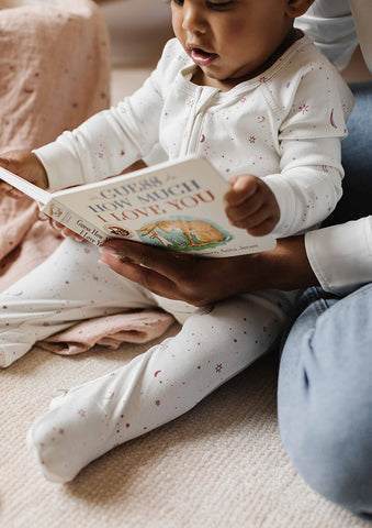 baby in sleeper reading book