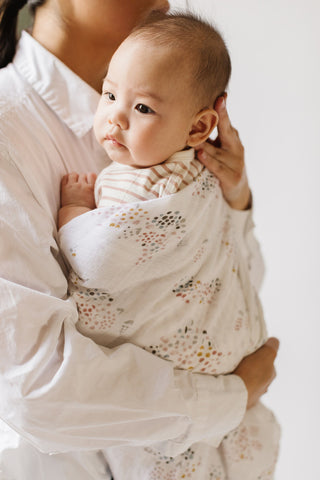 mother holding baby in swaddle