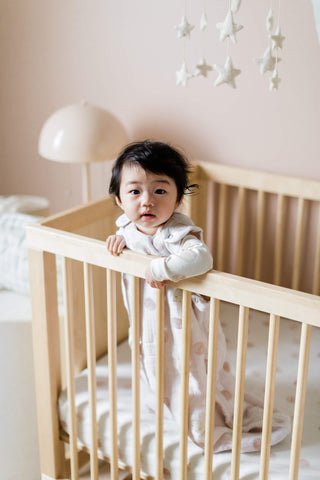 Baby wearing sleep bag in crib