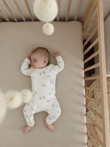 baby wearing sleeper in crib