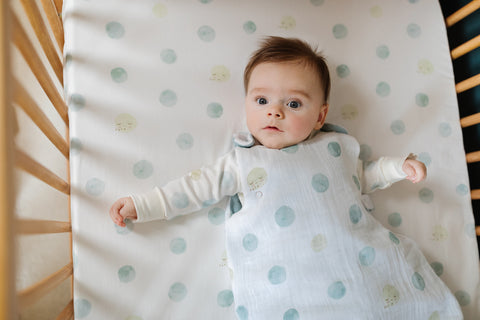 baby wearing sleep sack in crib