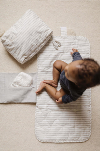 baby sitting on changing mat