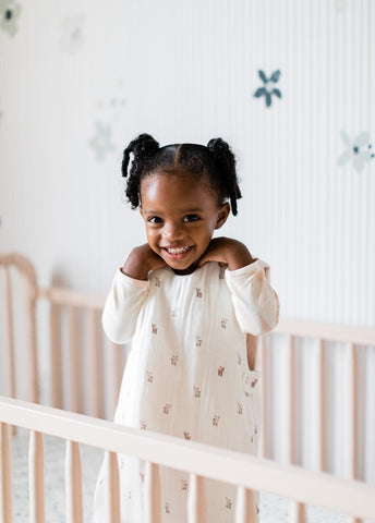 baby wearing sleep bag in crib