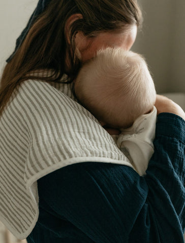 mother wearing burp cloth with baby 