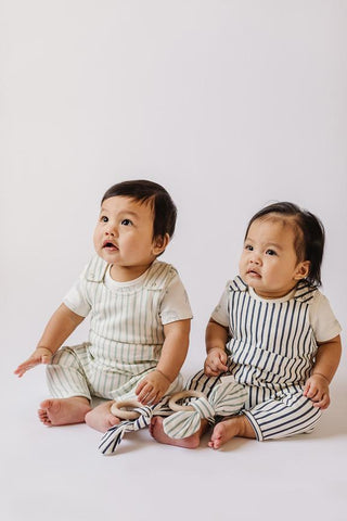newborn twins in matching overalls