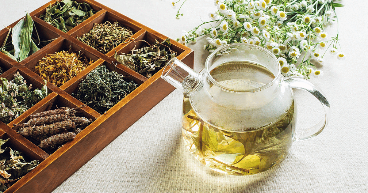 Loose herbal tea leaves, tea picture and chamomile on a table.