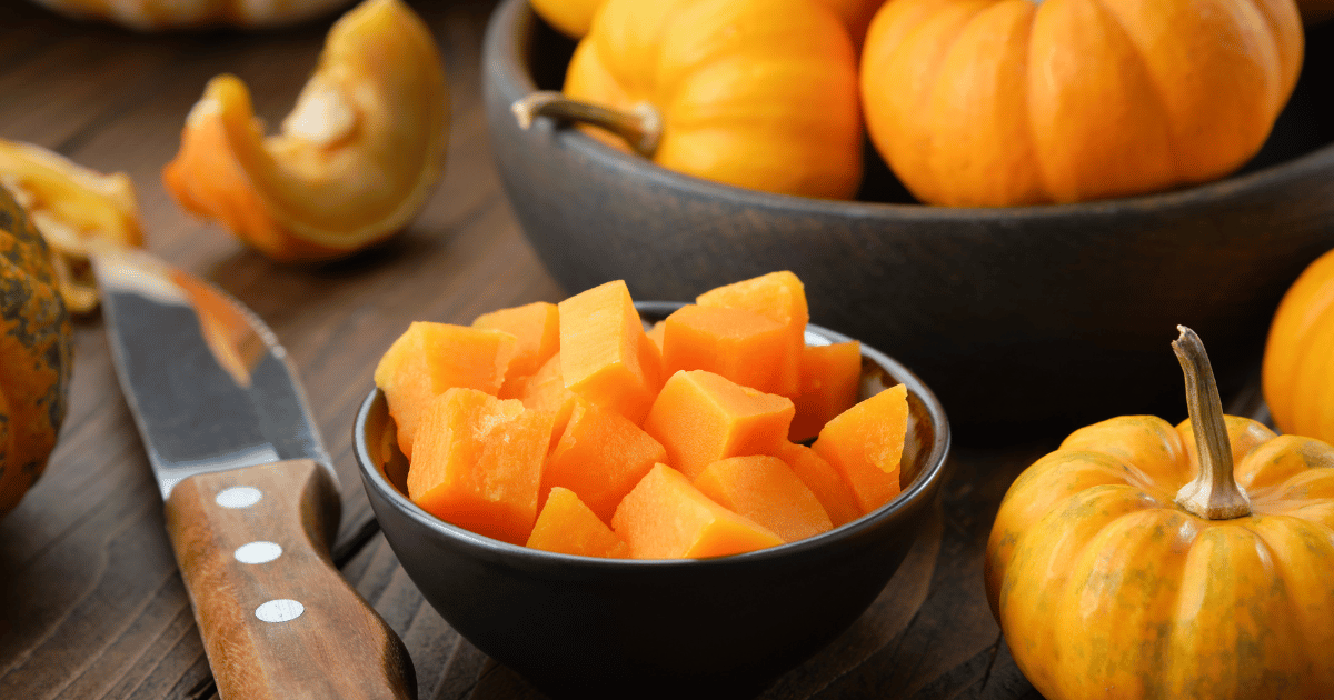 Bowl of chopped pumpkin pulp ready to cooking. Knife and pumpkin