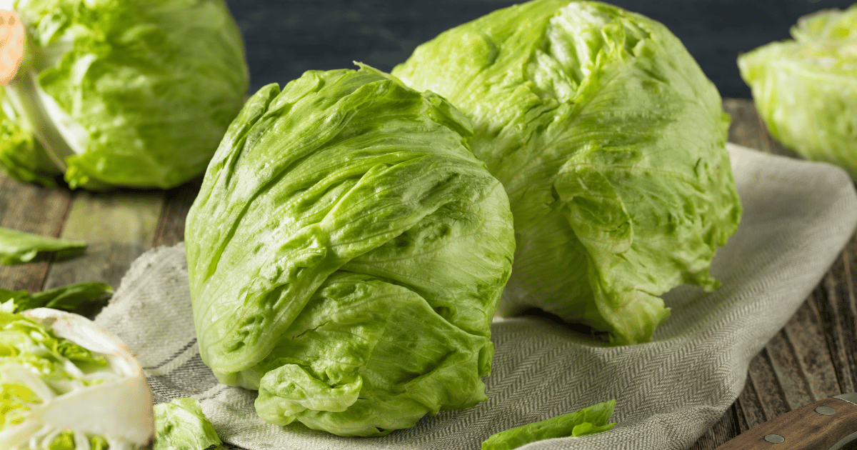 Iceberg lettuce on a cloth and wooden background.