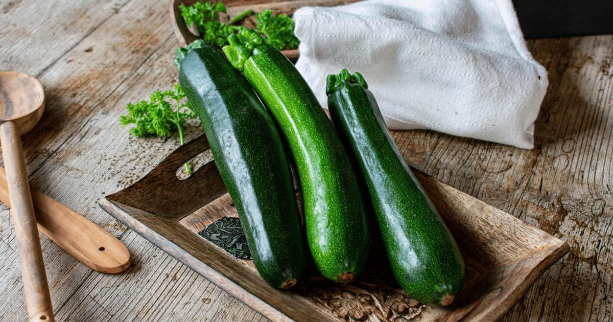 Fresh green zucchini on a rustic plate on a wooden table