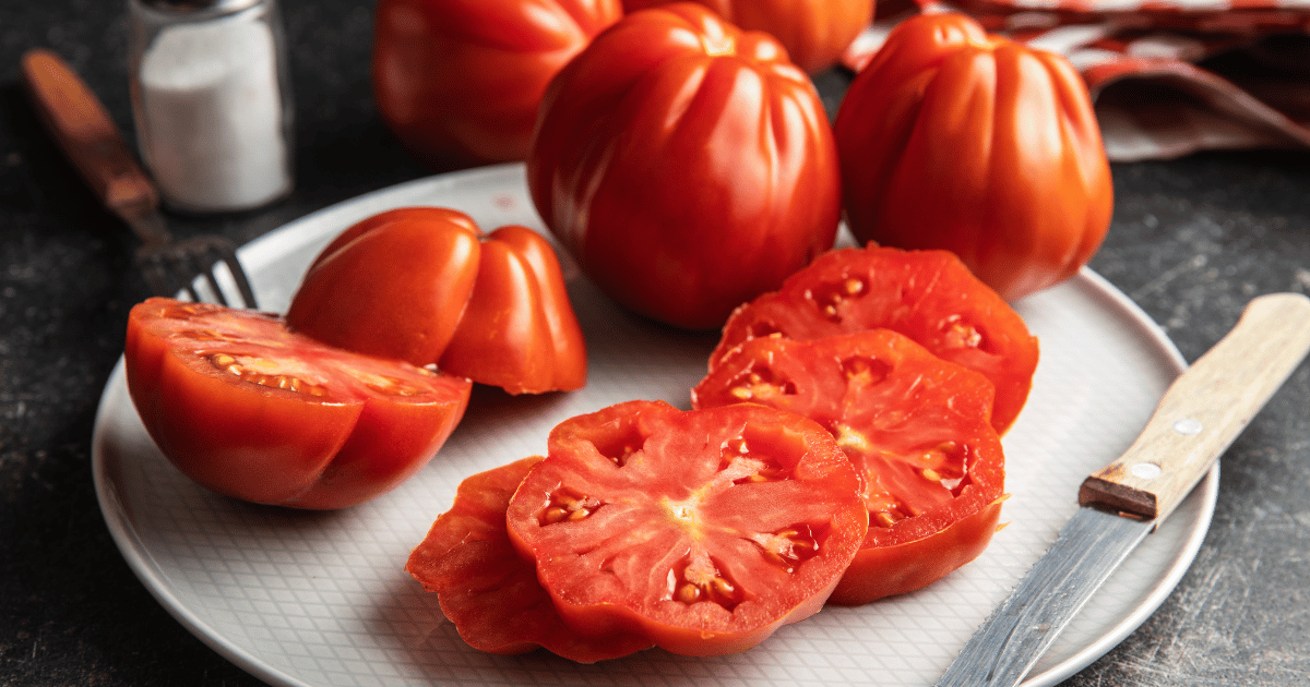 Red beefsteak tomatoes sliced on a plate.