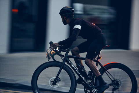 man in cycling clothes cycling on speed during dawn, the street and buildings in the background are blurred