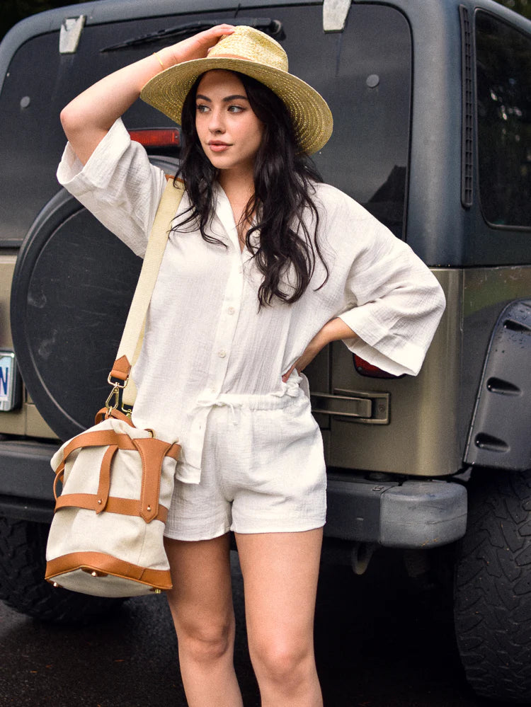 a model in a white matching cotton short set and a sun hat