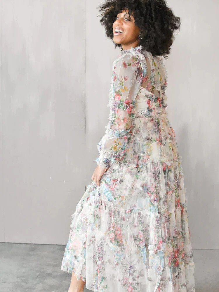 a model wearing a long sleeved, floral maxi dress