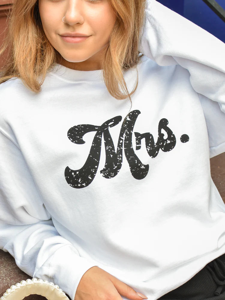 a model wearing a white “Mrs.” sweatshirt