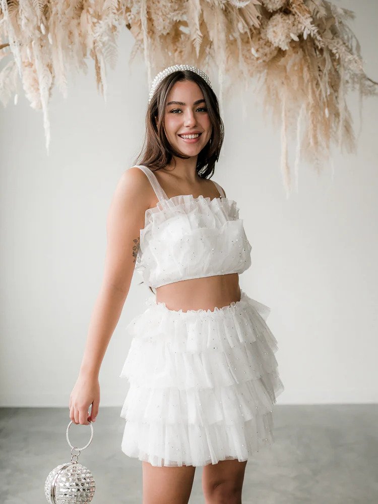 a model wearing a white tulle skirt and crop top set