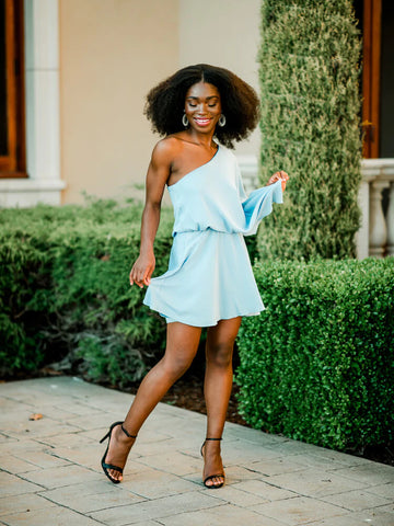 A Confête model holding flowers while wearing a Grace Ruffle Tier Midi Dress