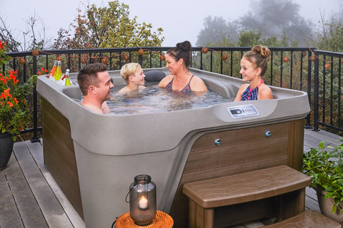 Family of 4 enjoying a hot tub on a cloudy day