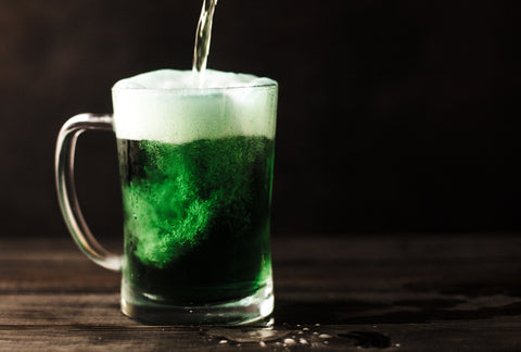 big glass of green, foamy beverage