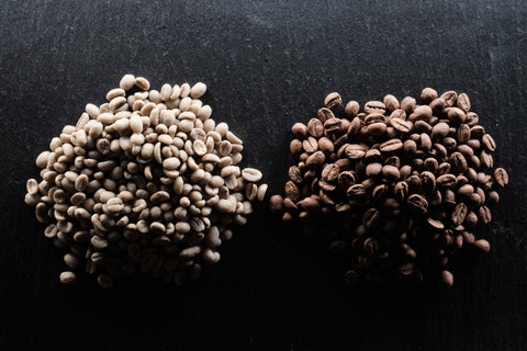 A handful of green coffee seeds on the left, a handful of roasted coffee seeds on the right. The roasted coffee seeds are noticeably bigger.